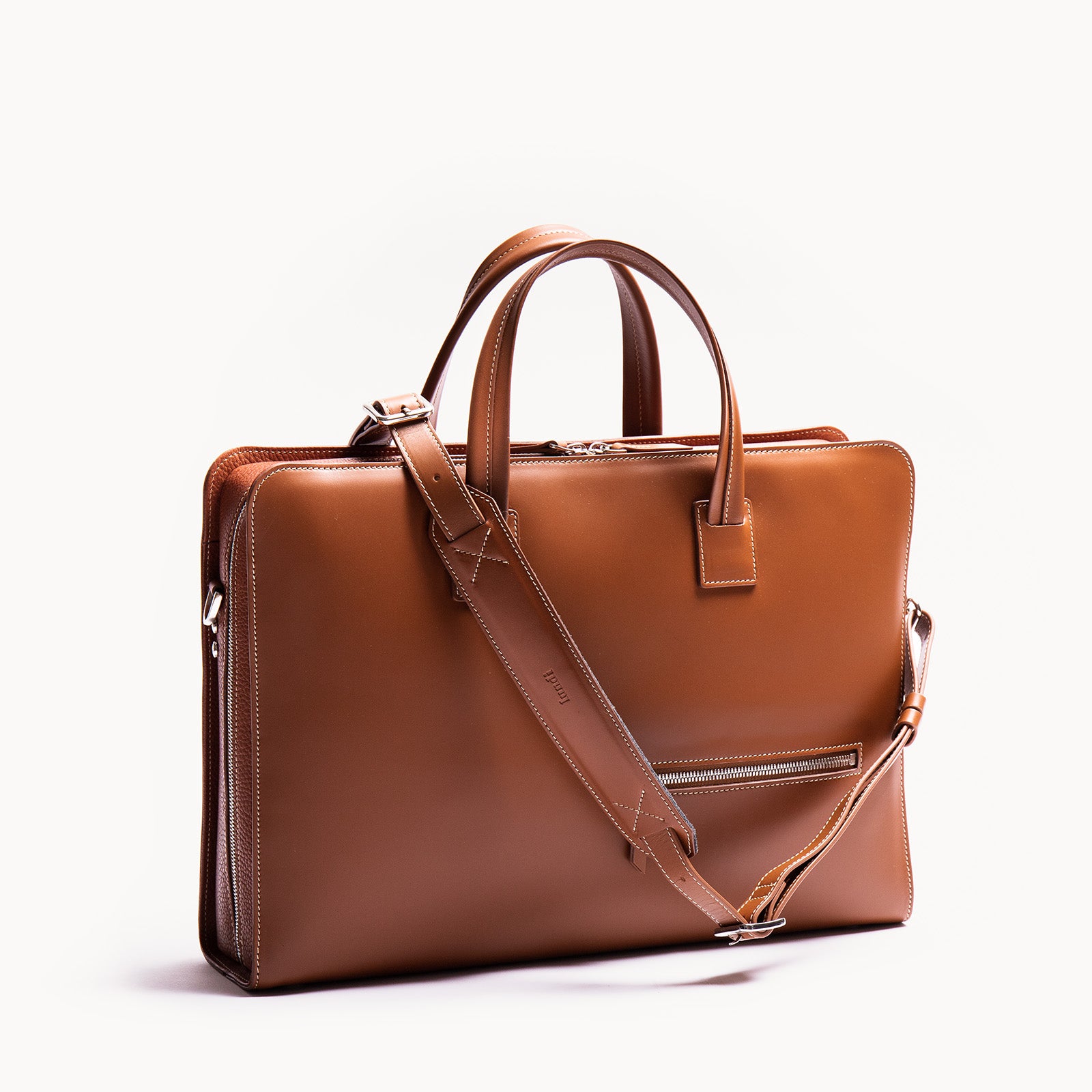 Briefcase en cuir lisse et grainé avec poche centrale matelassée pour ordinateur jusqu’à 16 pouces.