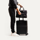 Porte-documents en toil et cuir accroché à une valise