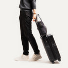 Porte-documents en toile et cuir porté sur une valise