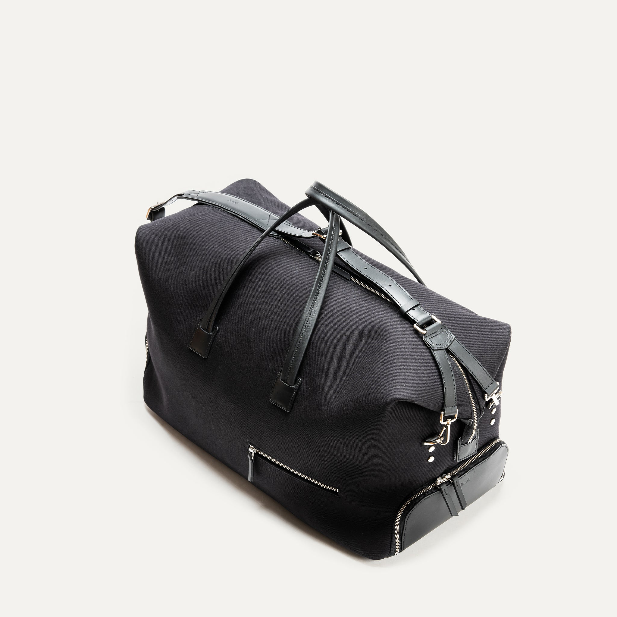 Vue en plongée d’un sac de voyage femme ou homme, compact et raffiné, parfait pour les courts séjours.