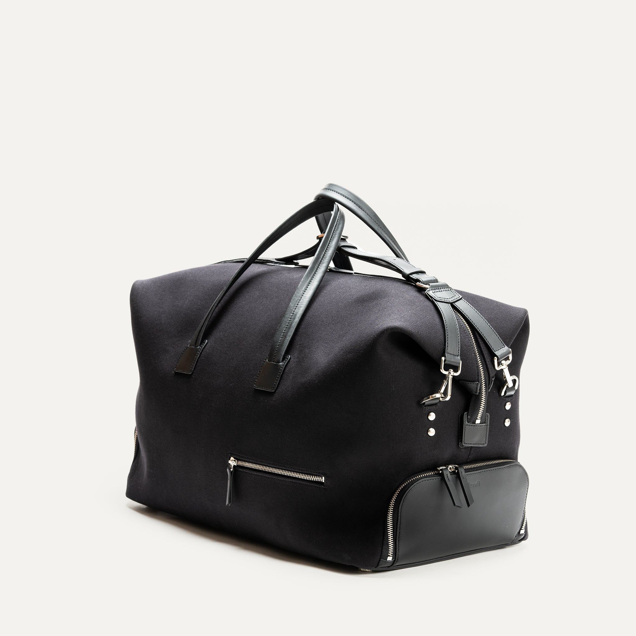 Sac de voyage en cuir et toile noir à l'allure raffiné et luxueux parfait pour embarquer avec élégance lors de votre voyage.