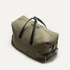 Sac weekender élégant avec poches extérieures zippées, confectionné en toile kaki et cuir noir.