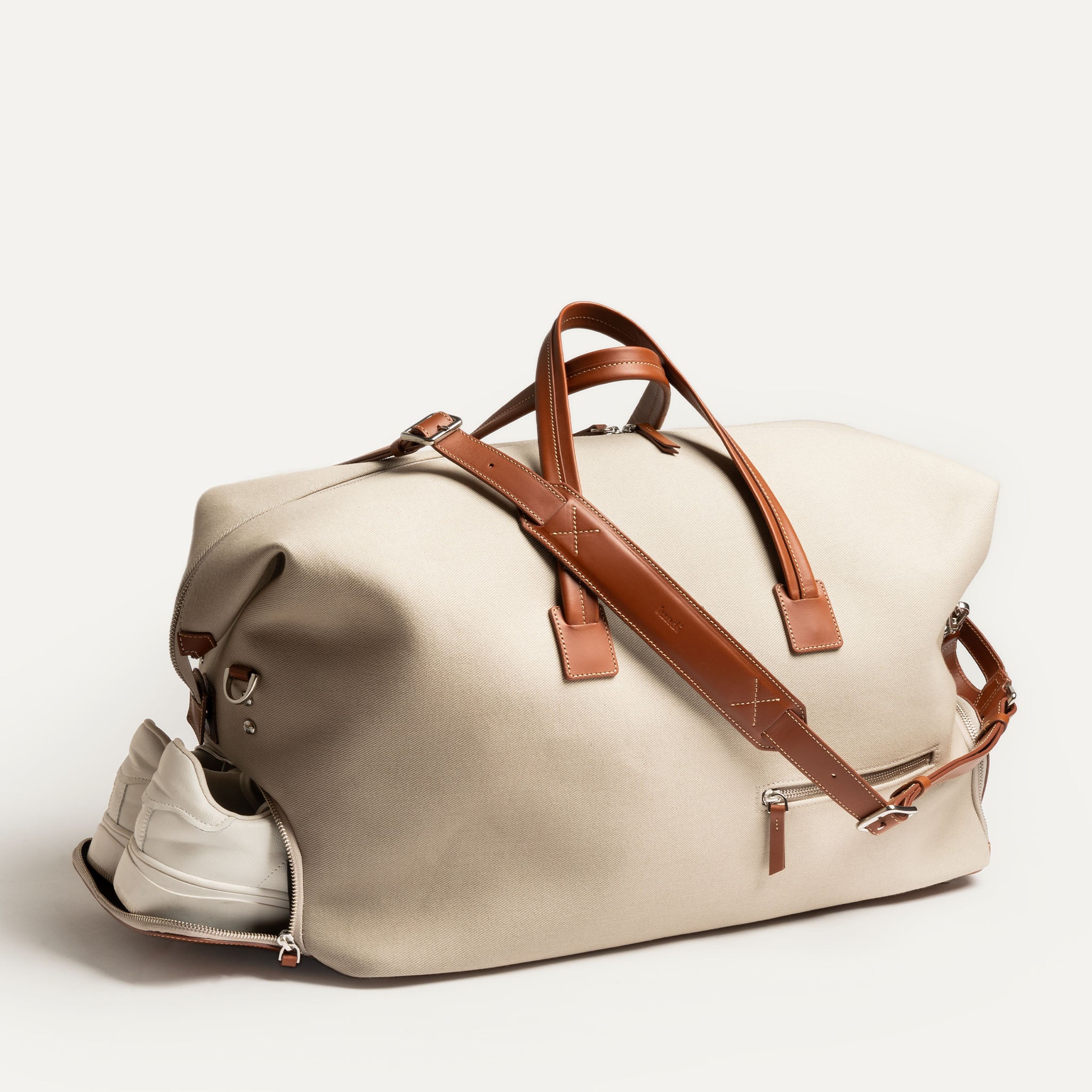 Sac de sport homme REMINGTON beige avec compartiment à chaussures ouvert et bandoulière ajustable.