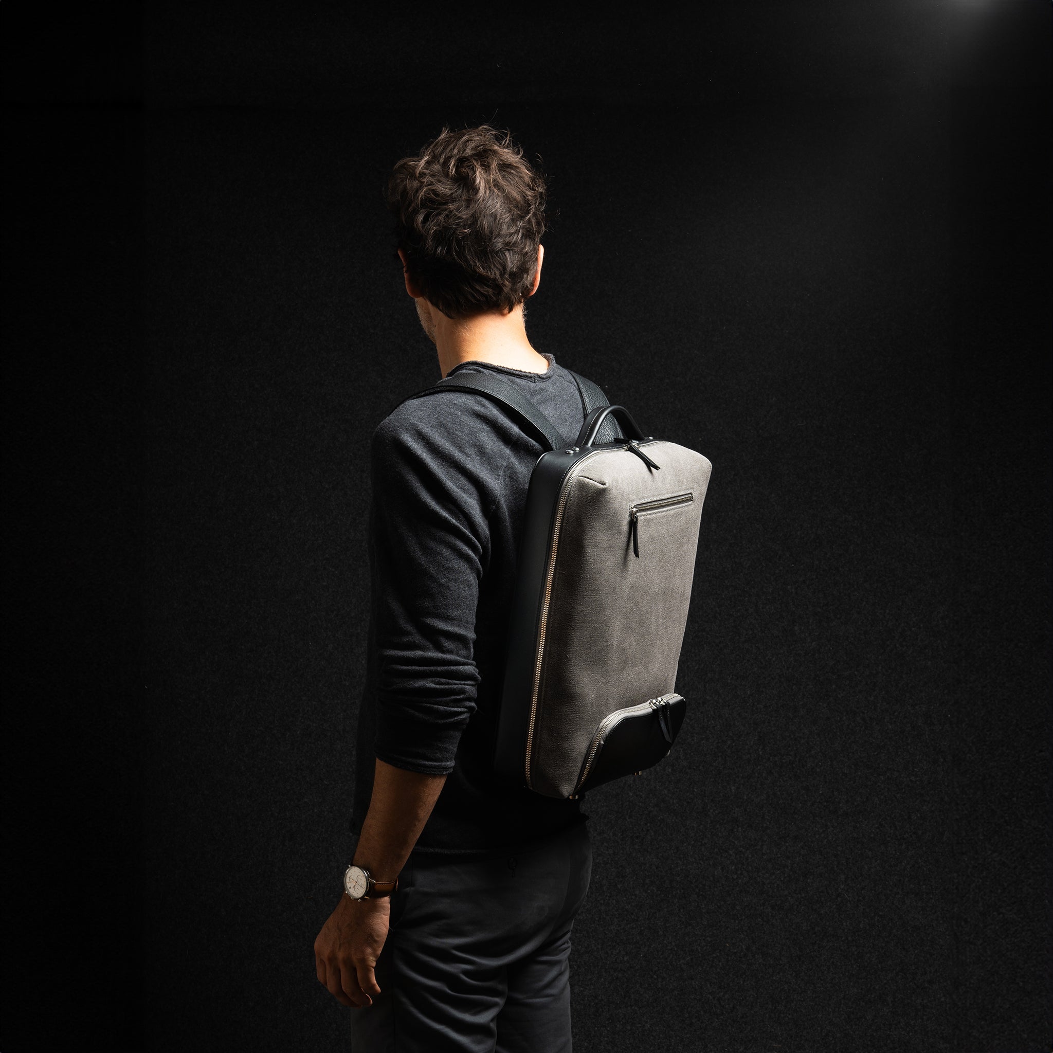 Sac à dos tendance homme en cuir et toile grise avec rangement passeport, format cabine et pour ordinateur.