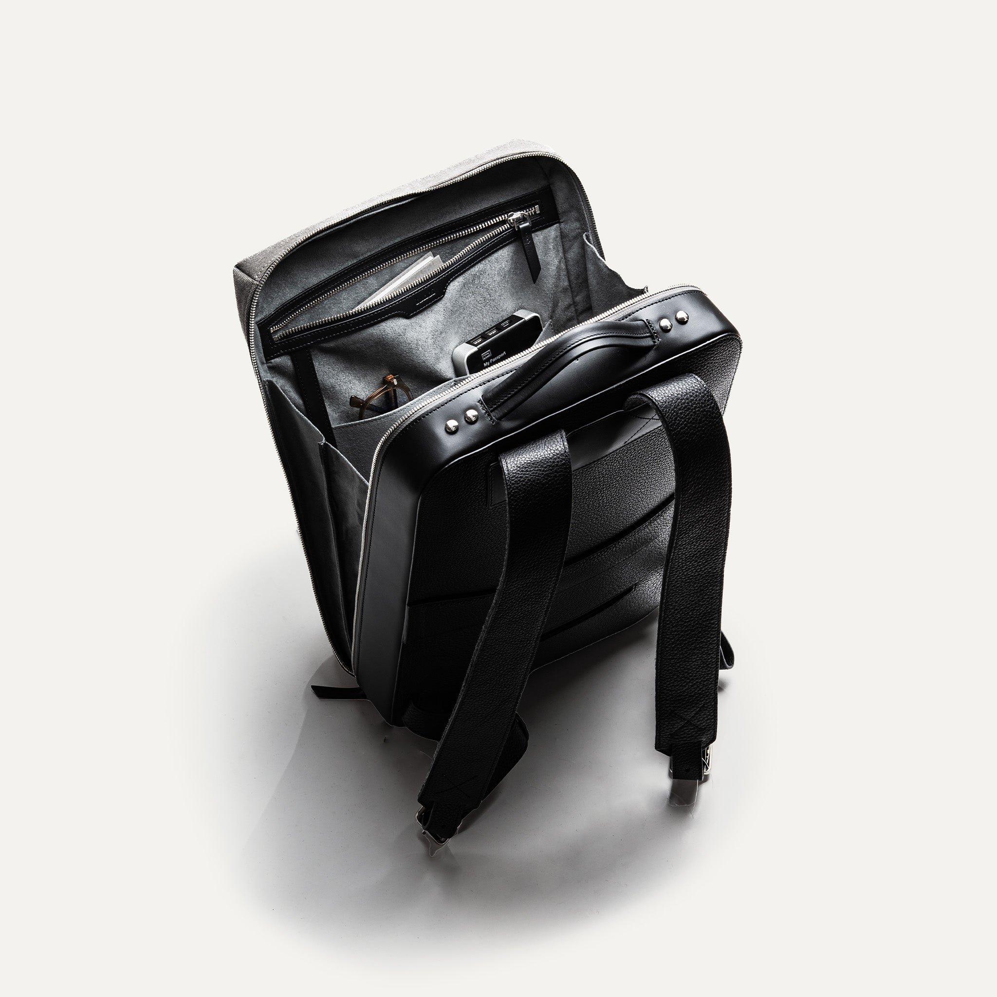 sac à dos en cuir et toile grise avec une ouverture large, parfait pour le travail et les déplacements.