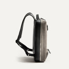 Profil fin d’un sac à dos ordinateur homme déperlant en toile grise, design épuré et luxueux.