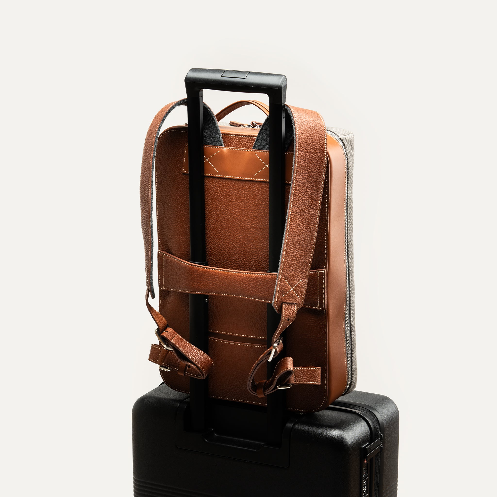 Sac à dos de voyage homme fixé sur valise avec bretelles ajustables et passant pour trolley.
