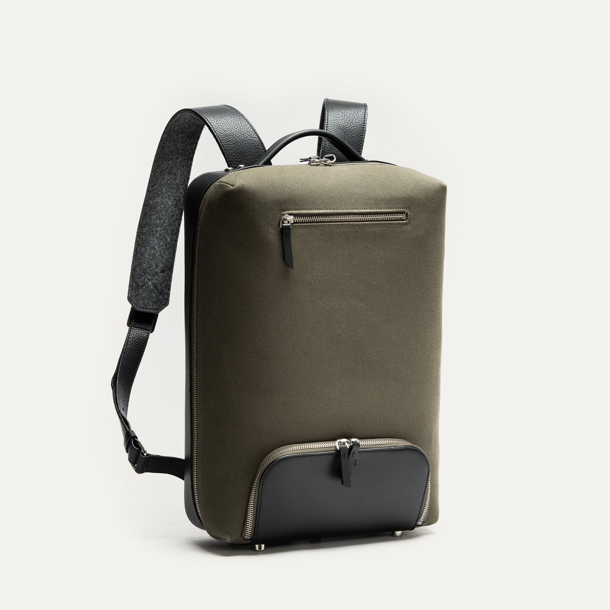 Sac à dos en cuir vert olive et noir, silhouette urbaine et chic.