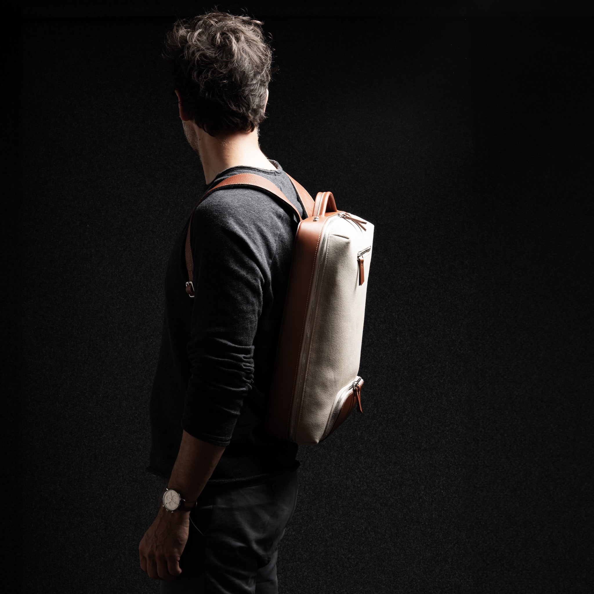 Homme de profil avec sac à dos en cuir homme, tendance, pour ordinateur et taille cabine 40x20x25.