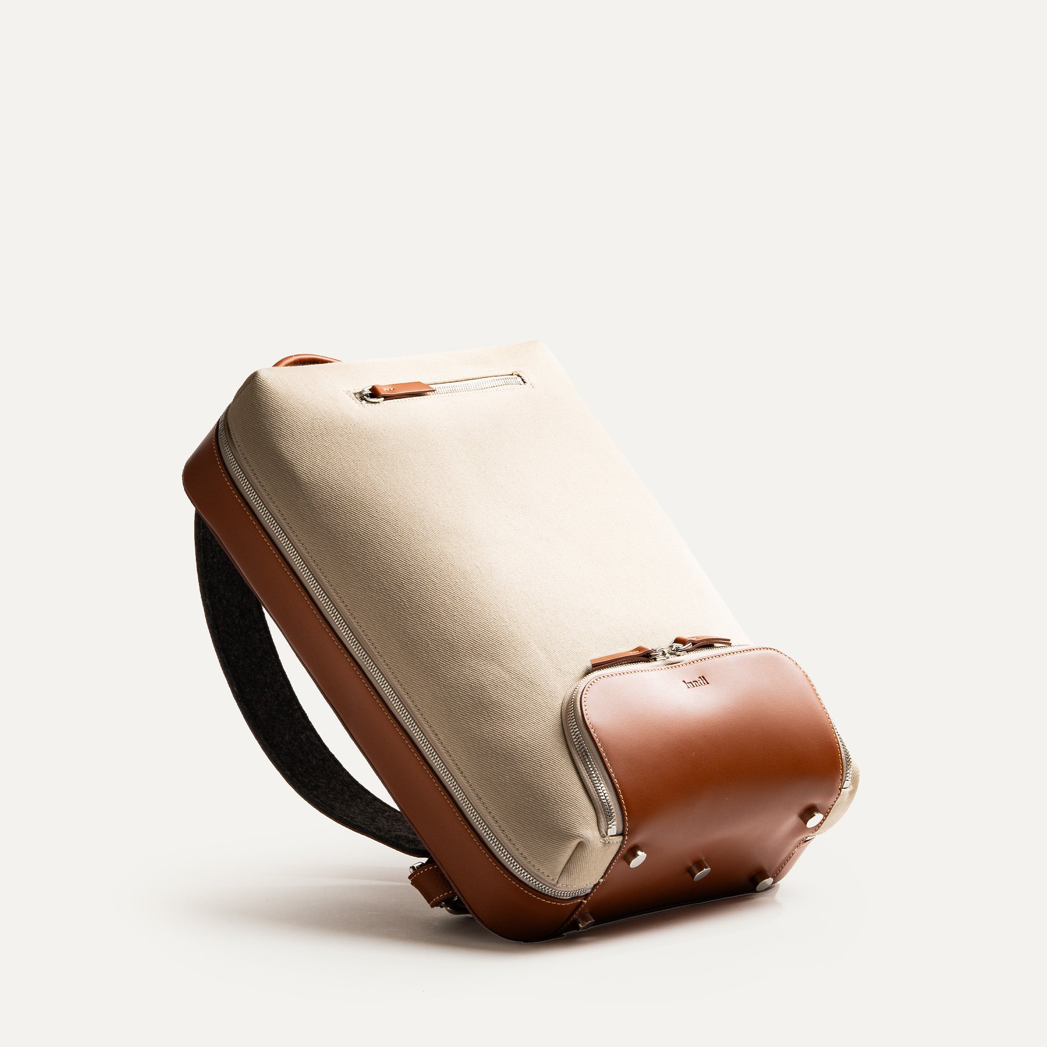 Base renforcée du sac à dos homme luxe, en cuir avec détails métalliques.