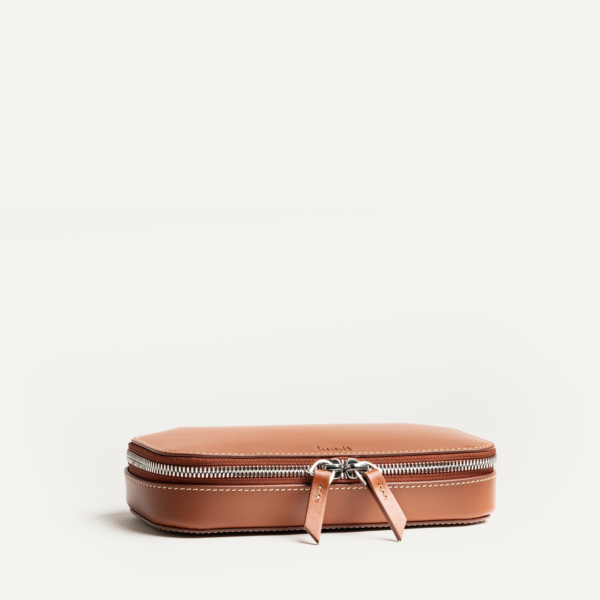 Trousse de toilette en cuir cognac pour homme élégant.