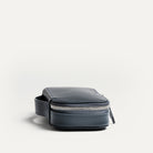 Trousse de toilette de voyage en cuir marine pratique pour voyager grâce à sa poignée intégrée.