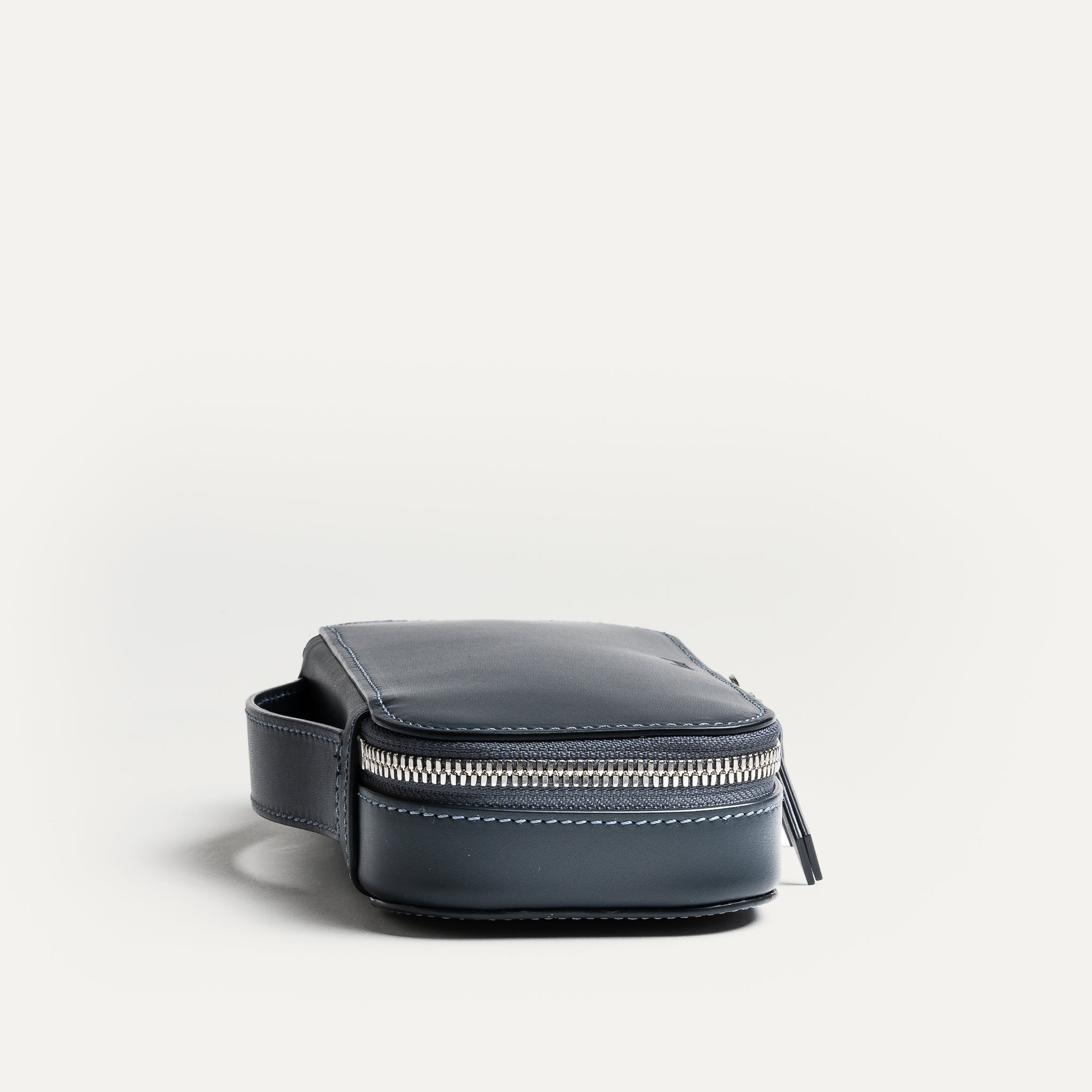 Trousse de toilette de voyage en cuir marine pratique pour voyager grâce à sa poignée intégrée.