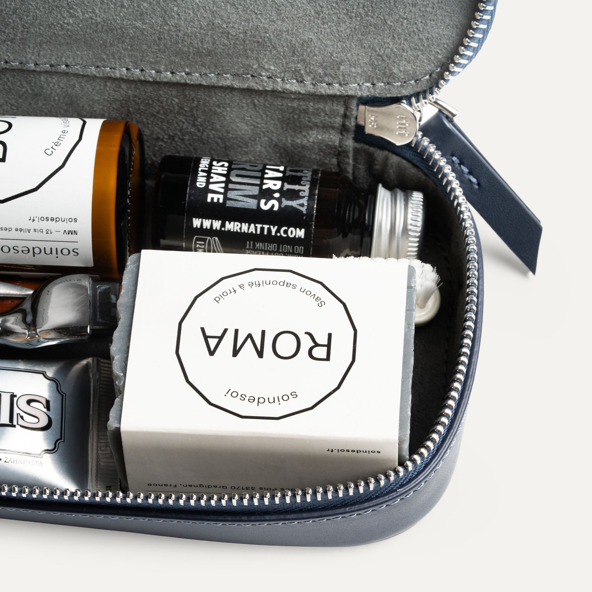 Trousse de toilette avec compartiment intérieur et poche zippée pour accessoires.