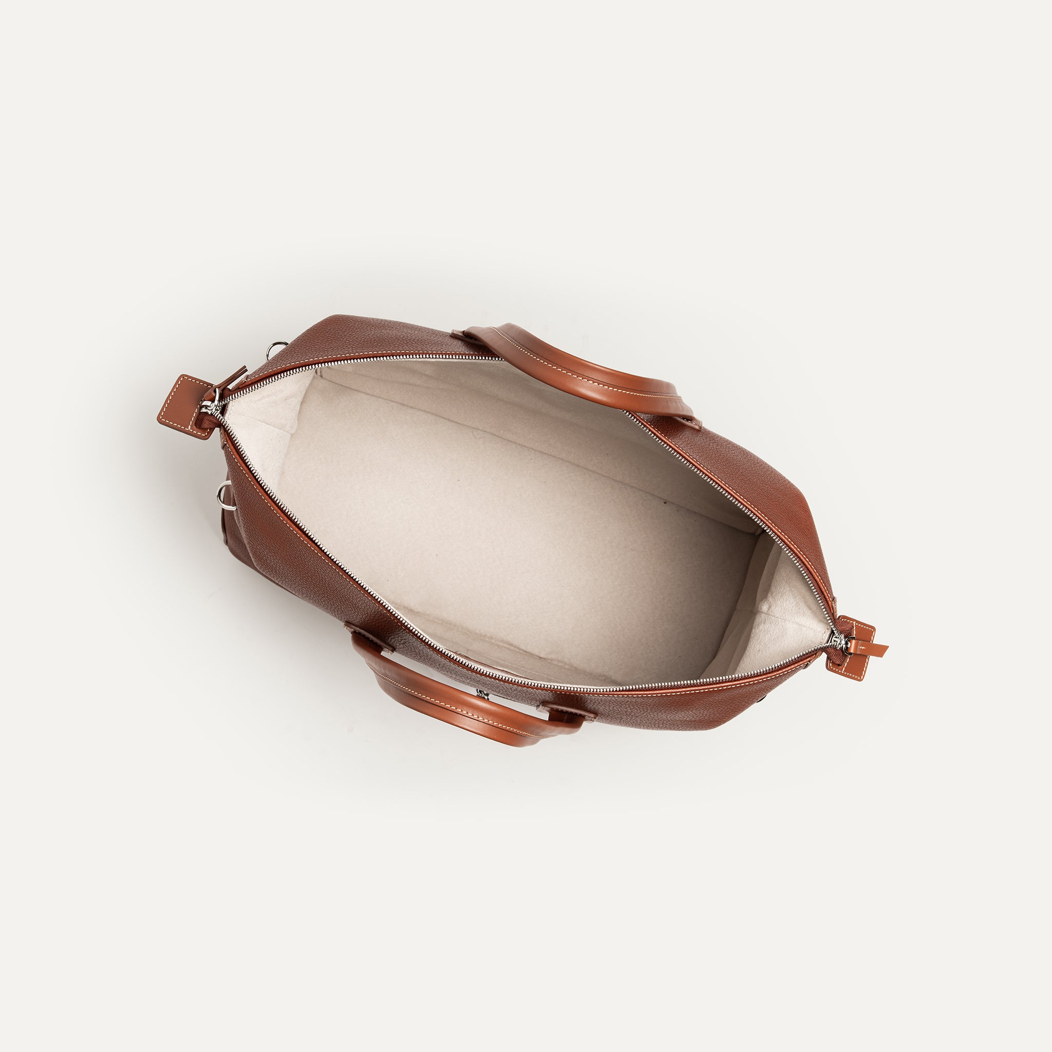 Sac de sport en cuir marron, intérieur spacieux doublé en Alcantara, idéal pour affaires et loisirs.