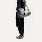 Sac de voyage homme tenu sous le bras.