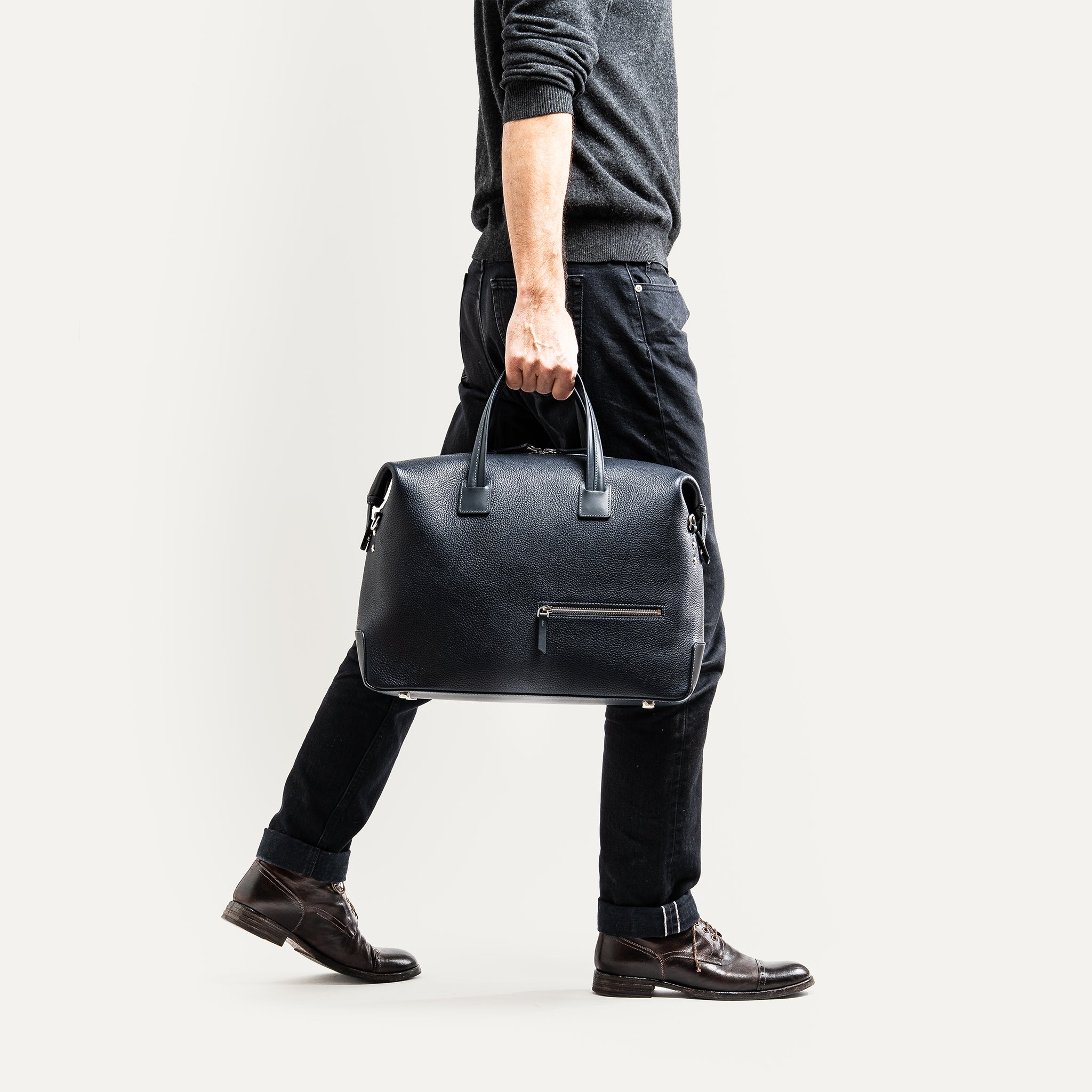 Sac de voyage homme tenu à la main d'un homme très chic à l'allure professionnelle.