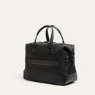 Sac de voyage homme en cuir noir élégant, équipé d'un passant trolley pour fixation sur valise.