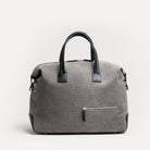 Sac weekender en toile grise et cuir noir, fermeture éclair métal brillante, format 48 heures.