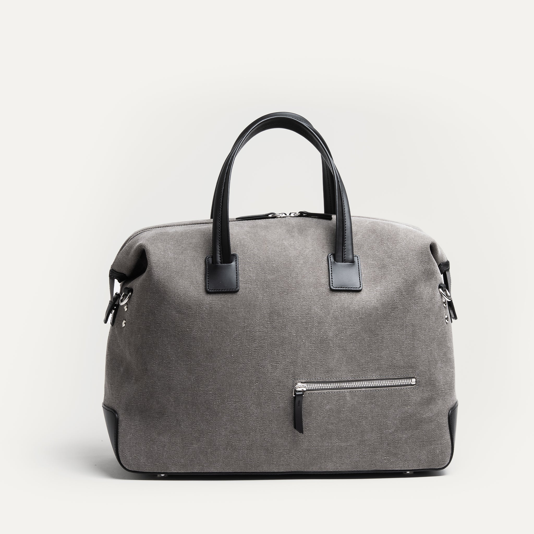 Sac weekender en toile grise et cuir noir, fermeture éclair métal brillante, format 48 heures.