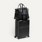 Sac week end femme sur une valise tenu par un passant trolley fonctionnel.