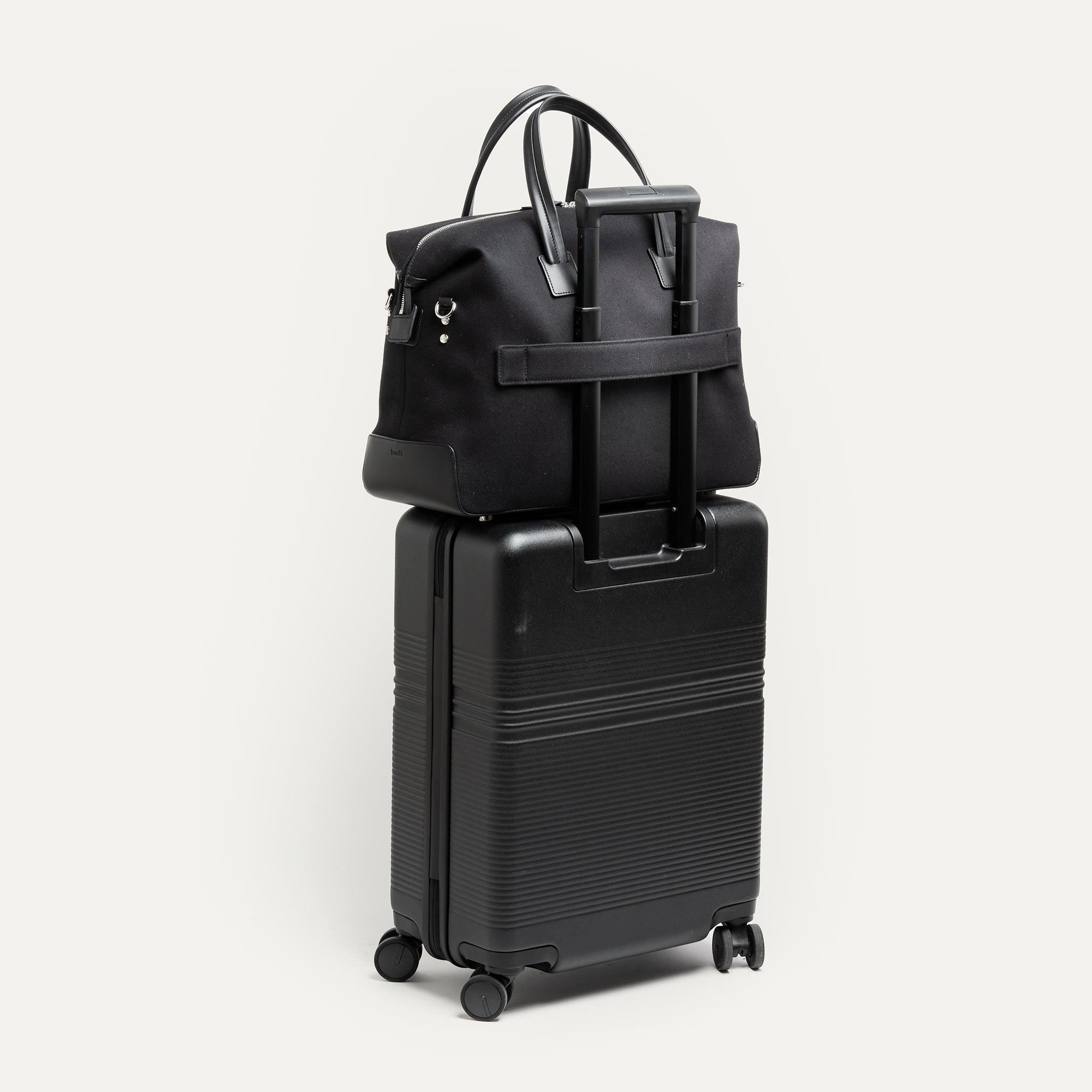 Sac week end femme sur une valise tenu par un passant trolley fonctionnel.