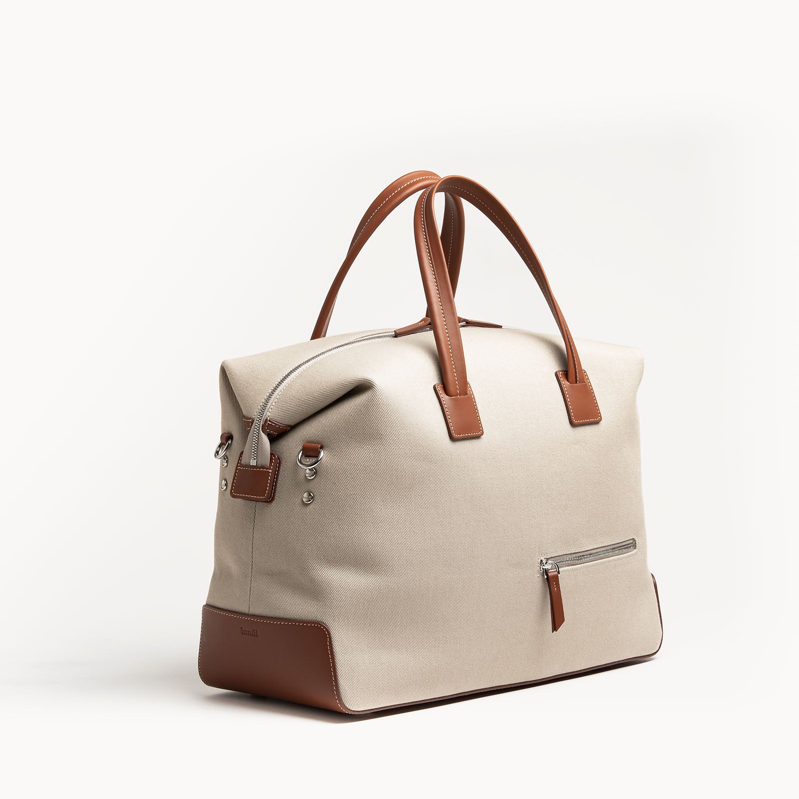 Sac de voyage en toile beige et cuir cognac, format 48 heures, design épuré.
