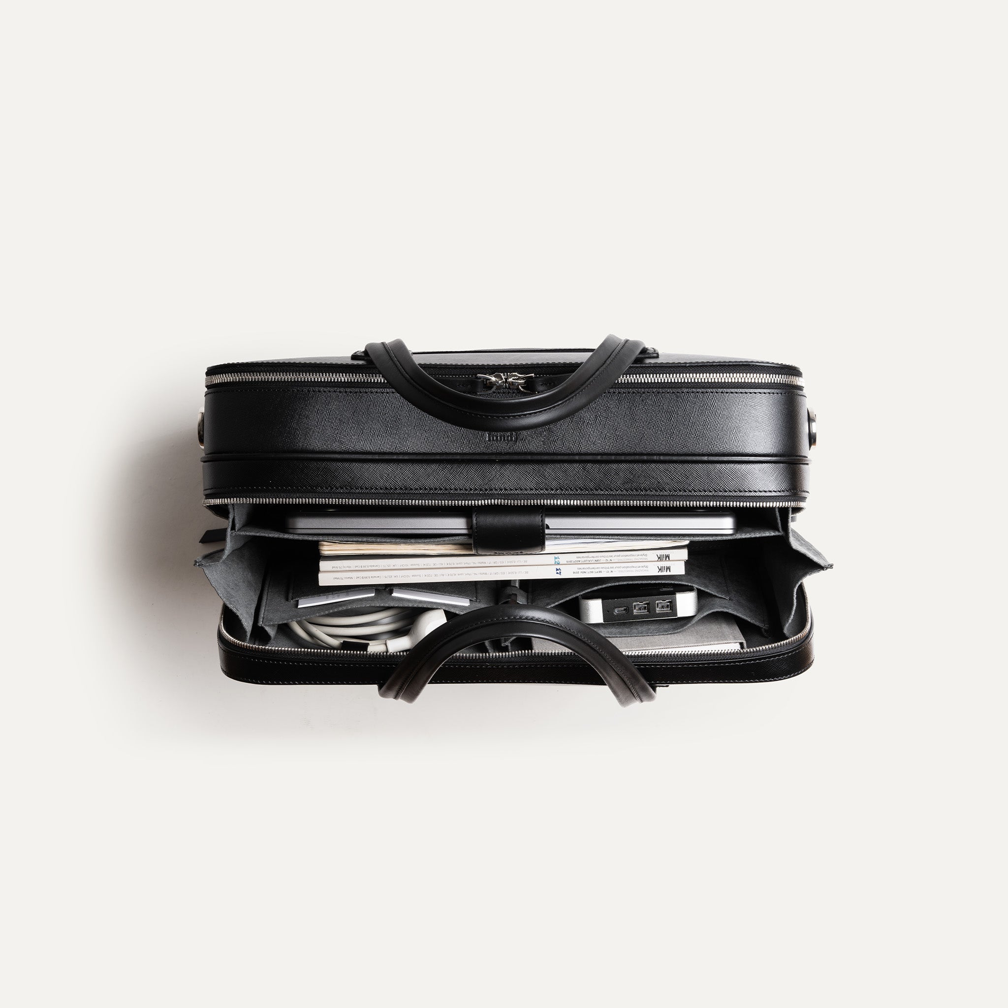 Attaché case Cardignac en cuir conçu par lundi, avec poche zippée extérieure et compartiment ordinateur jusqu’à 17 pouces.