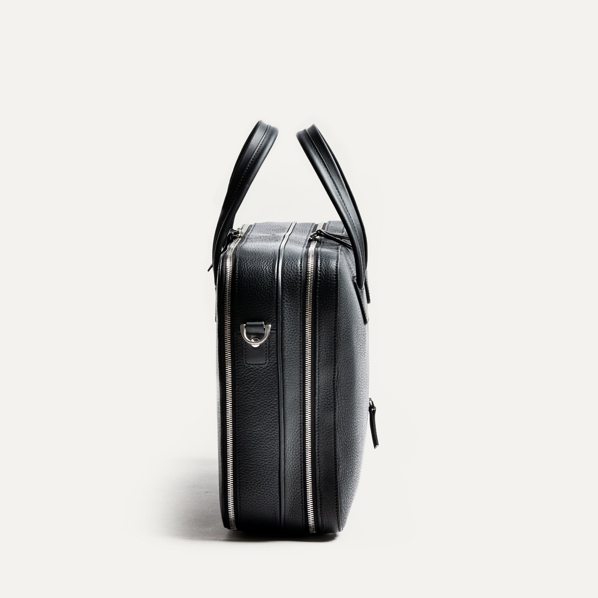 Sac à main homme TILIO II en cuir noir vu de profil avec double zip et détails métalliques haut de gamme.