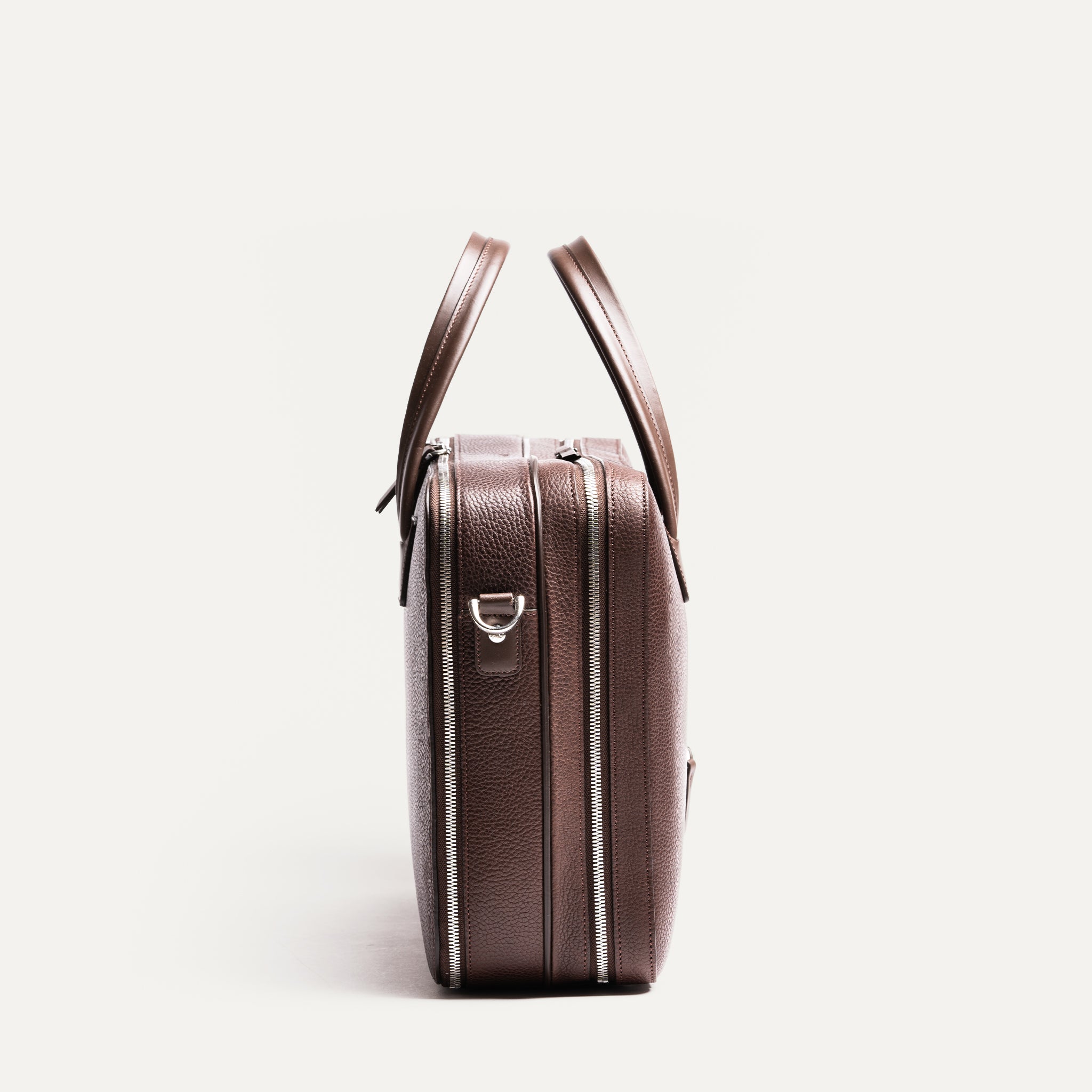 Ce briefcase se caractérise par sa simplicité et son efficacité, avec des lignes épurées et une construction en cuir grainé.