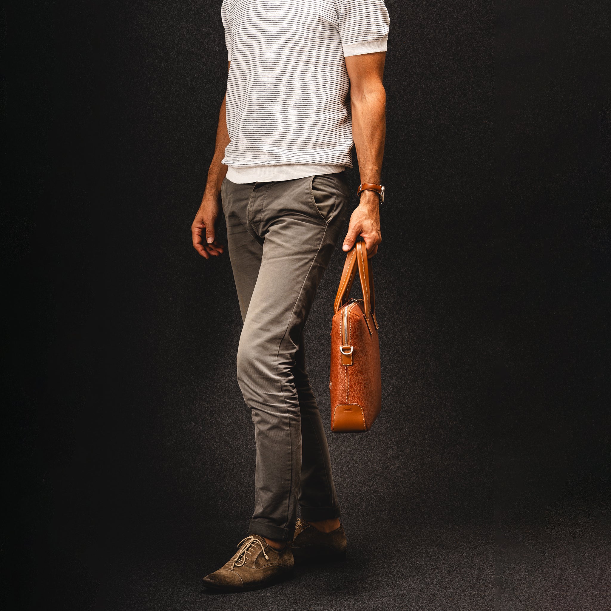 Sac à main homme camel porté avec tenue casual élégante, parfait pour un style de tous les jours.