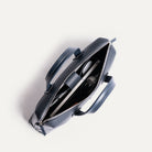 Cartable cuir homme avec rangements organisés pour laptop, câbles, documents et accessoires.