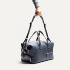 Sac weekender en cuir marine WILSON équipé d'une bandoulière ajustable pour voyager avec confort et un look raffiné.