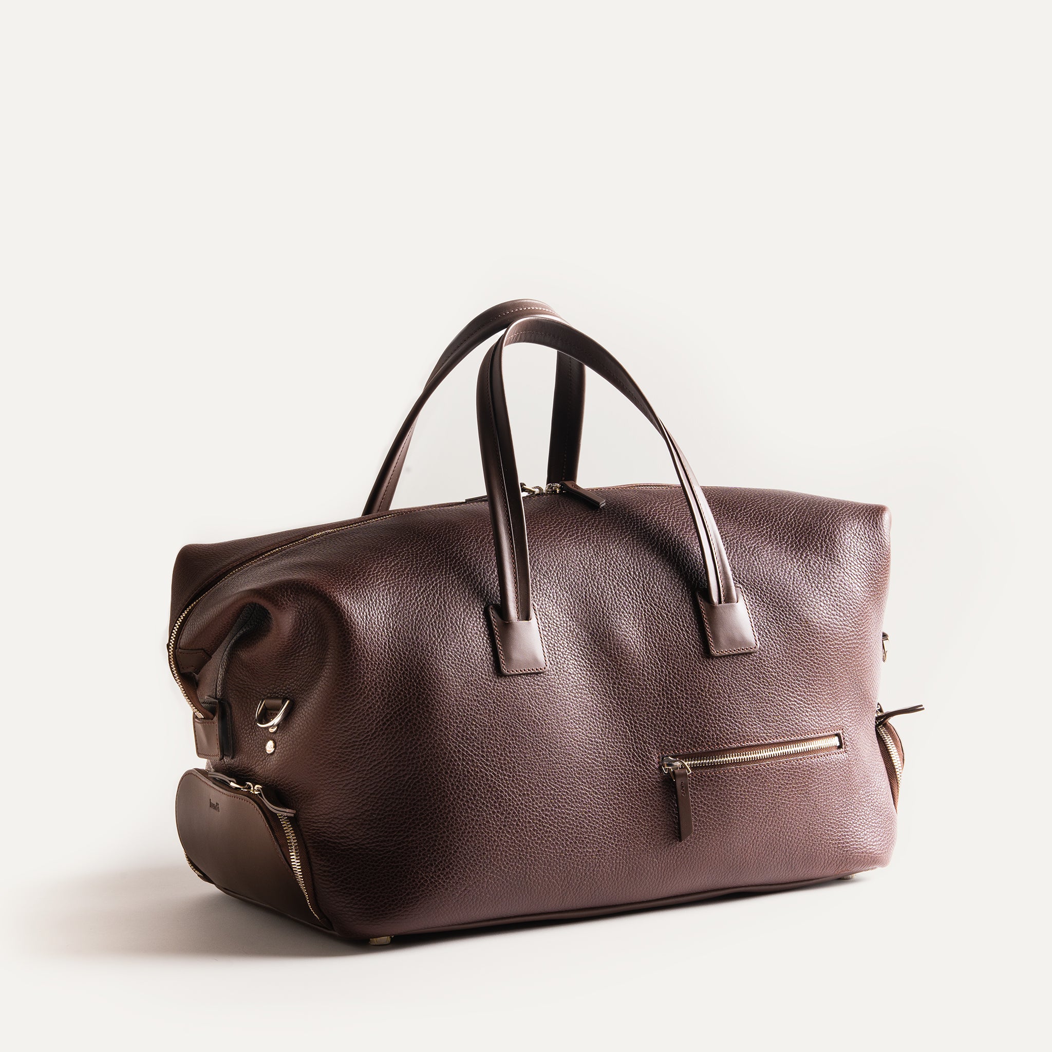Sac week end pour homme en cuir grainé au tannage végétal apporte toute la souplesse nécessaire à notre sac de voyage, une poche signature placée sur la face avant du sac vous permettra d'y glisser votre passeport.