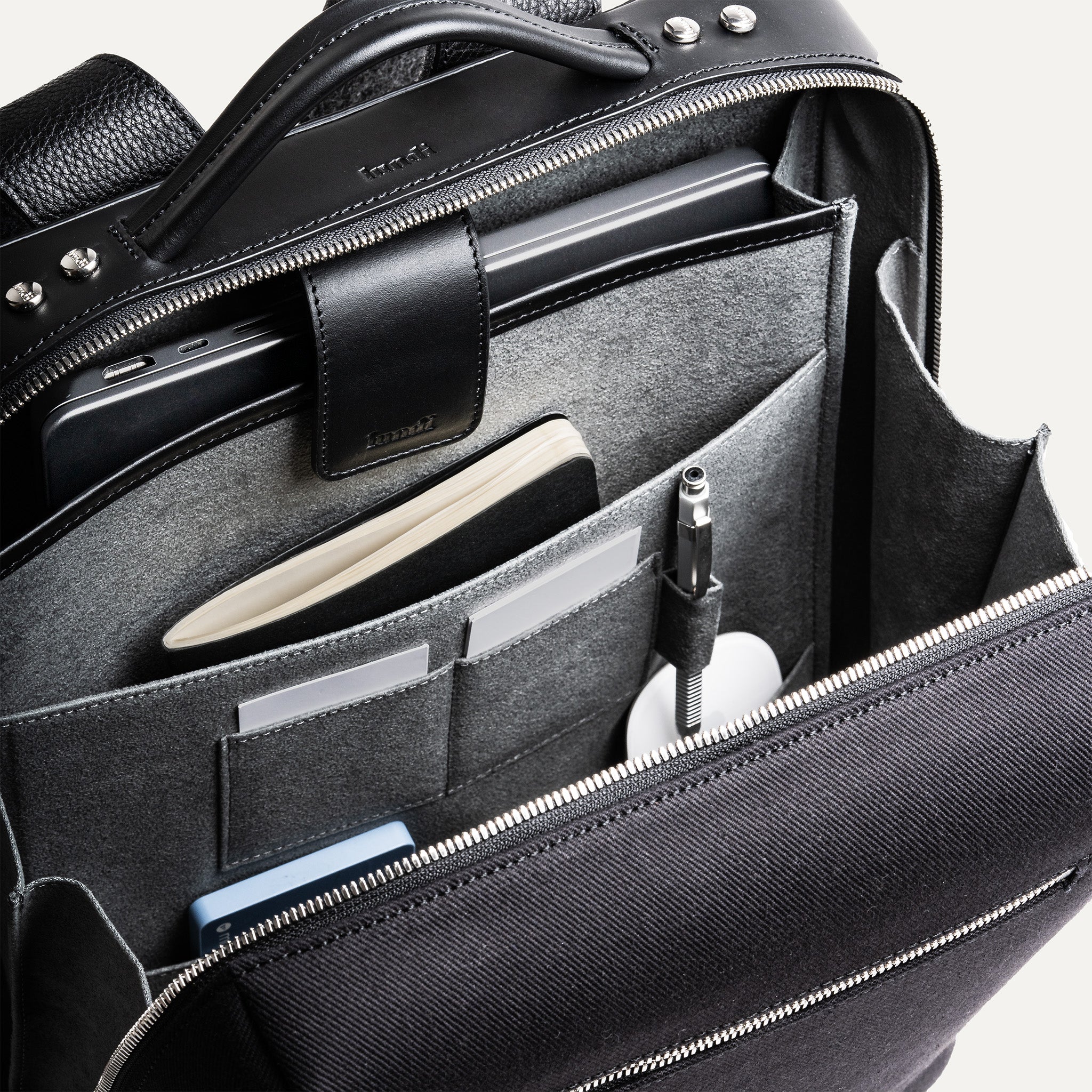 Sac à dos de voyage homme en cuir avec compartiment pratique pour accessoires.