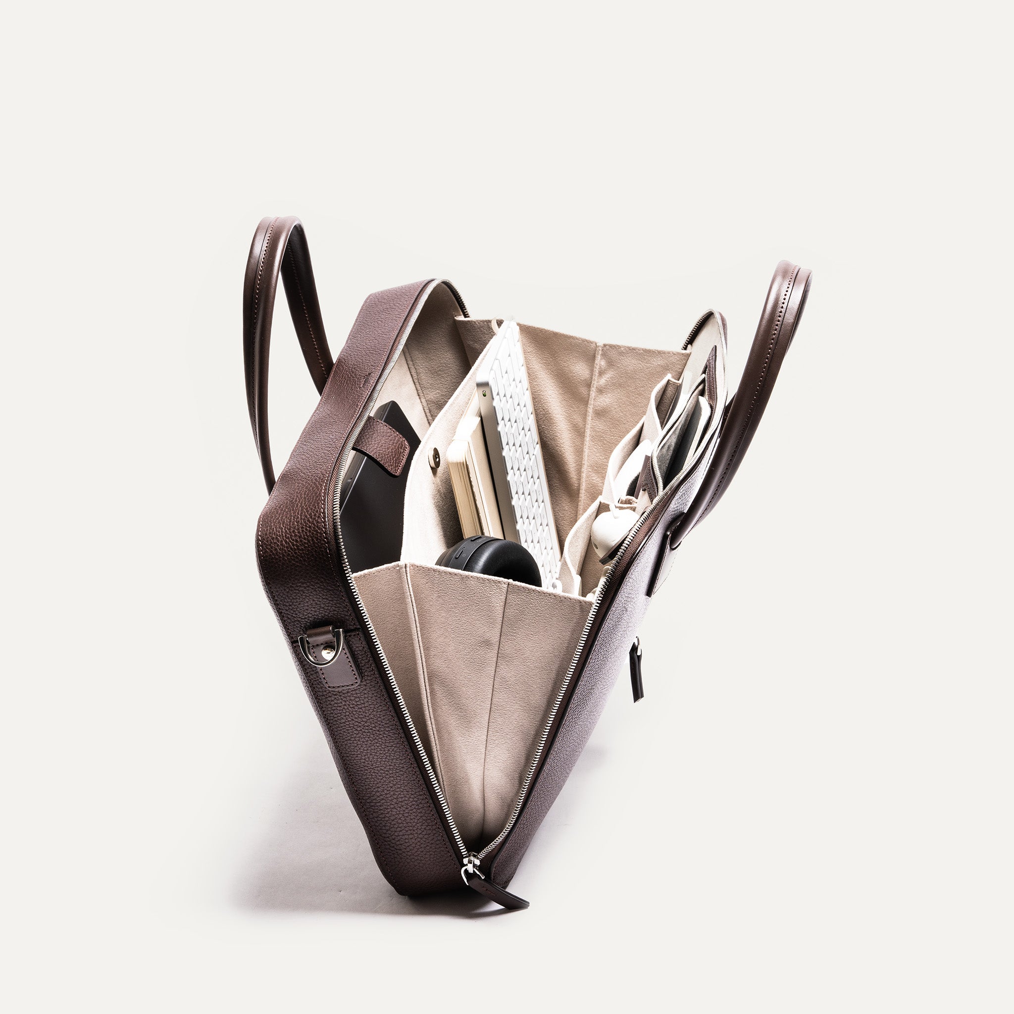 Intérieur bien organisé d’un sac ordinateur contenant un casque audio, un ordinateur portable et des documents, parfait pour les trajets quotidiens.