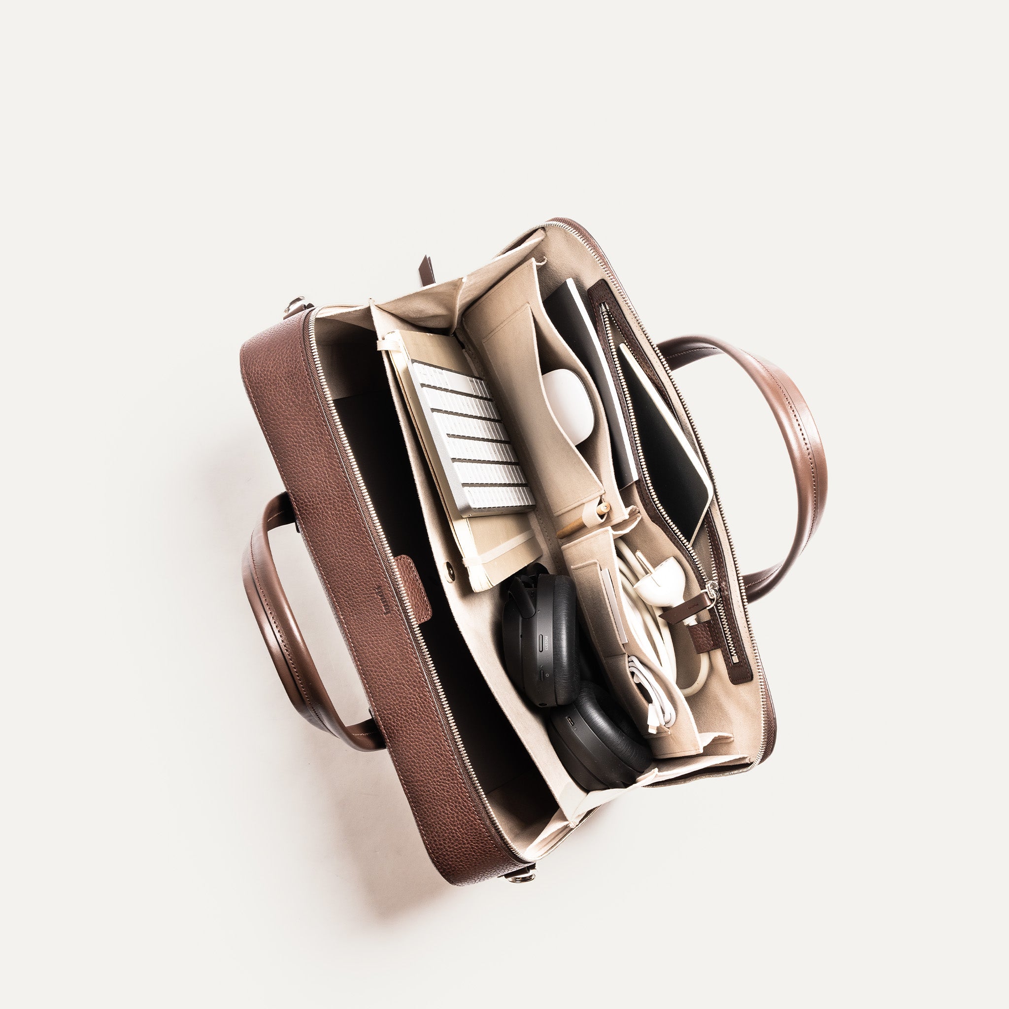 Organisation interne d’un cartable cuir homme avec rangements pour chargeurs, accessoires et documents, conçu pour l'efficacité.