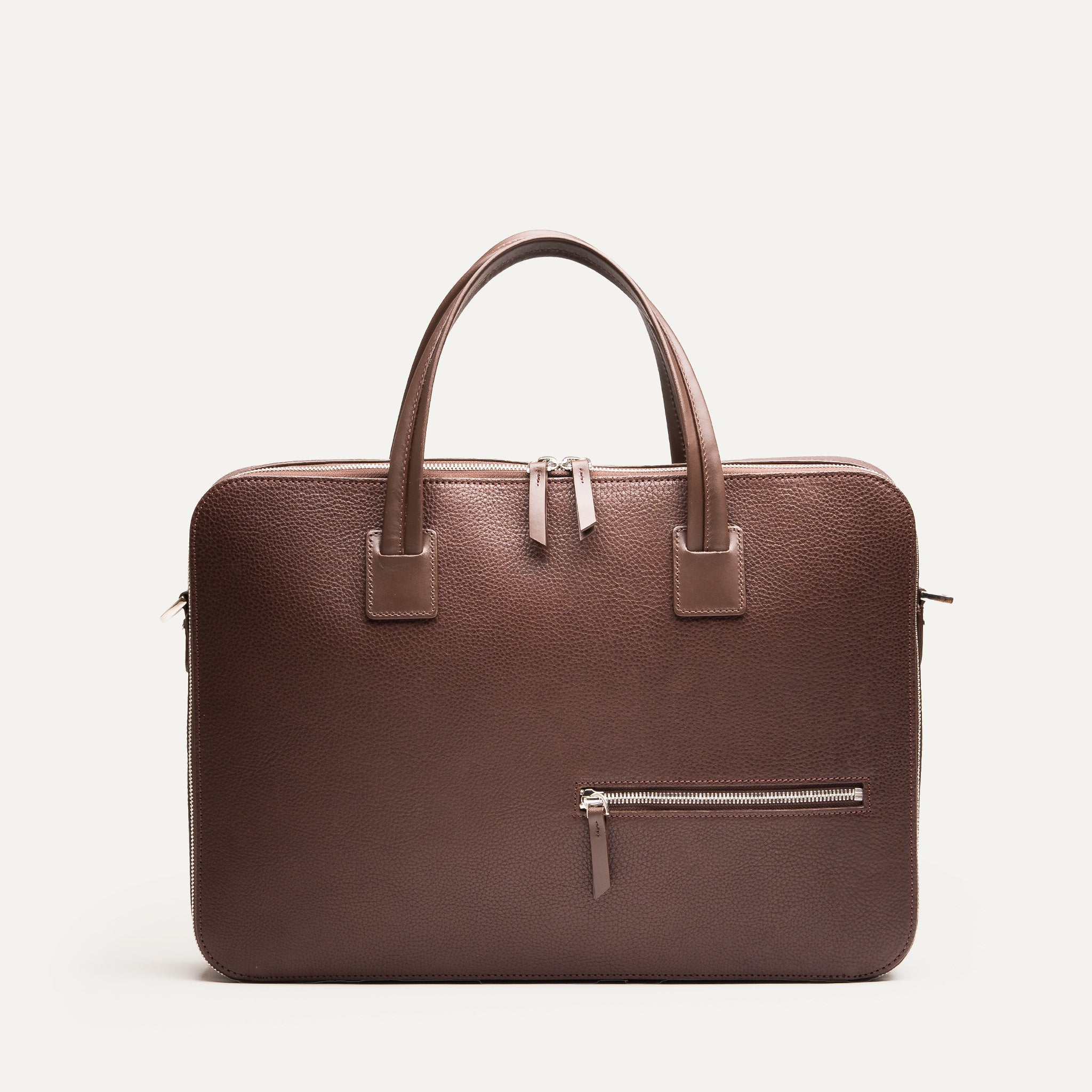 Face avant d’un porte document homme au design minimaliste avec fermeture éclair et doubles poignées pour une allure chic.