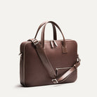 Elégant briefcase en cuir avec bandoulière amovible et poche zippée frontale, idéal pour un usage professionnel.