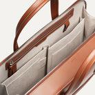 Porte document en cuir camel intégrant des rangements pour le quotidien.