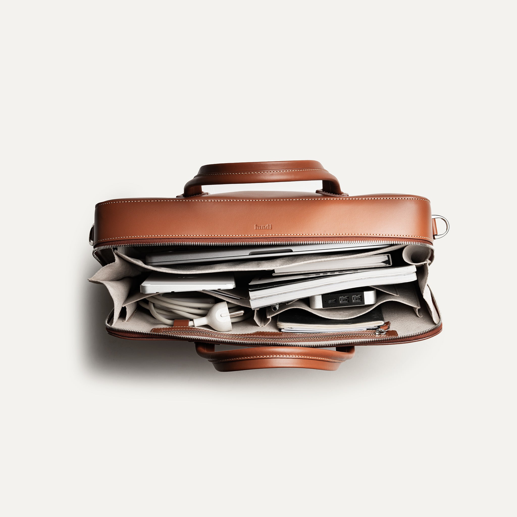 Porte document avec des rangements fonctionnels pour l'ordinateur, chargeur, carnet.