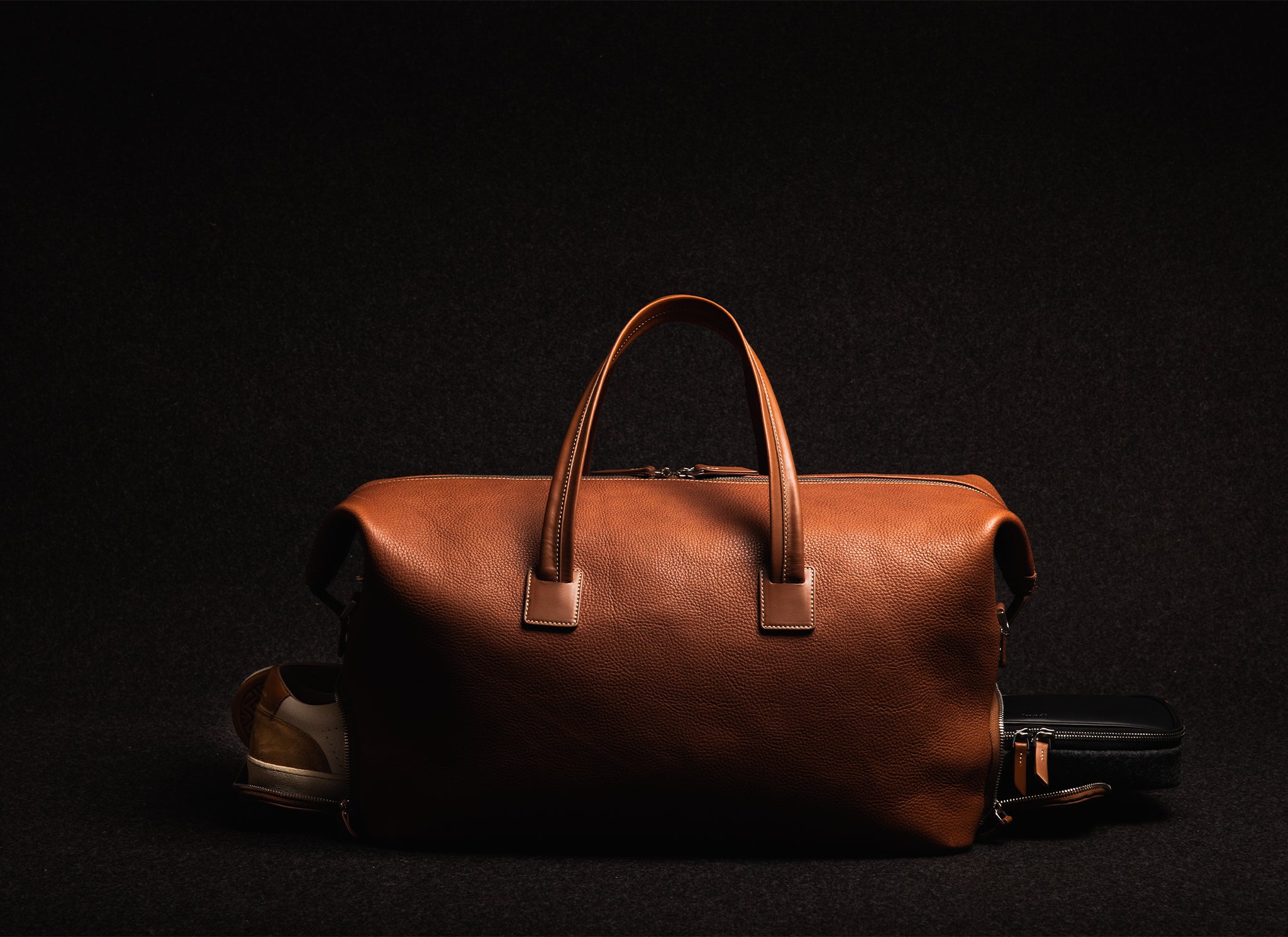 Sac de voyage en cuir cognac est parfait pour les voyages courts, offrant un compartiment pratique pour vos chaussures et votre trousse de toilette.