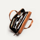 Attaché case en cuir et toile cognac avec des espaces réfléchis pour être pratique.