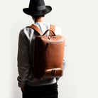 Sac à dos homme en cuir porté avec style, idéal pour ordinateur et look chic.