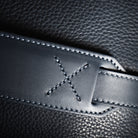 Sac de voyage en cuir marine est équipé de poignées pour un port à la main et d'une sangle en cuir réglable pour un port à l'épaule.