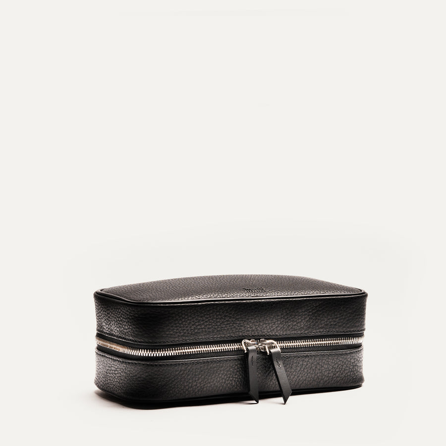 Trousse de toilette homme cuir noire fermée vue de face, élégante et fonctionnelle pour les voyages et le quotidien.