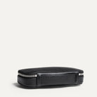 Vue de dos d'une trousse de toilette avec sa sangle pour la porter ou la suspendre, en cuir grainé noir et intérieur en Alcantara 