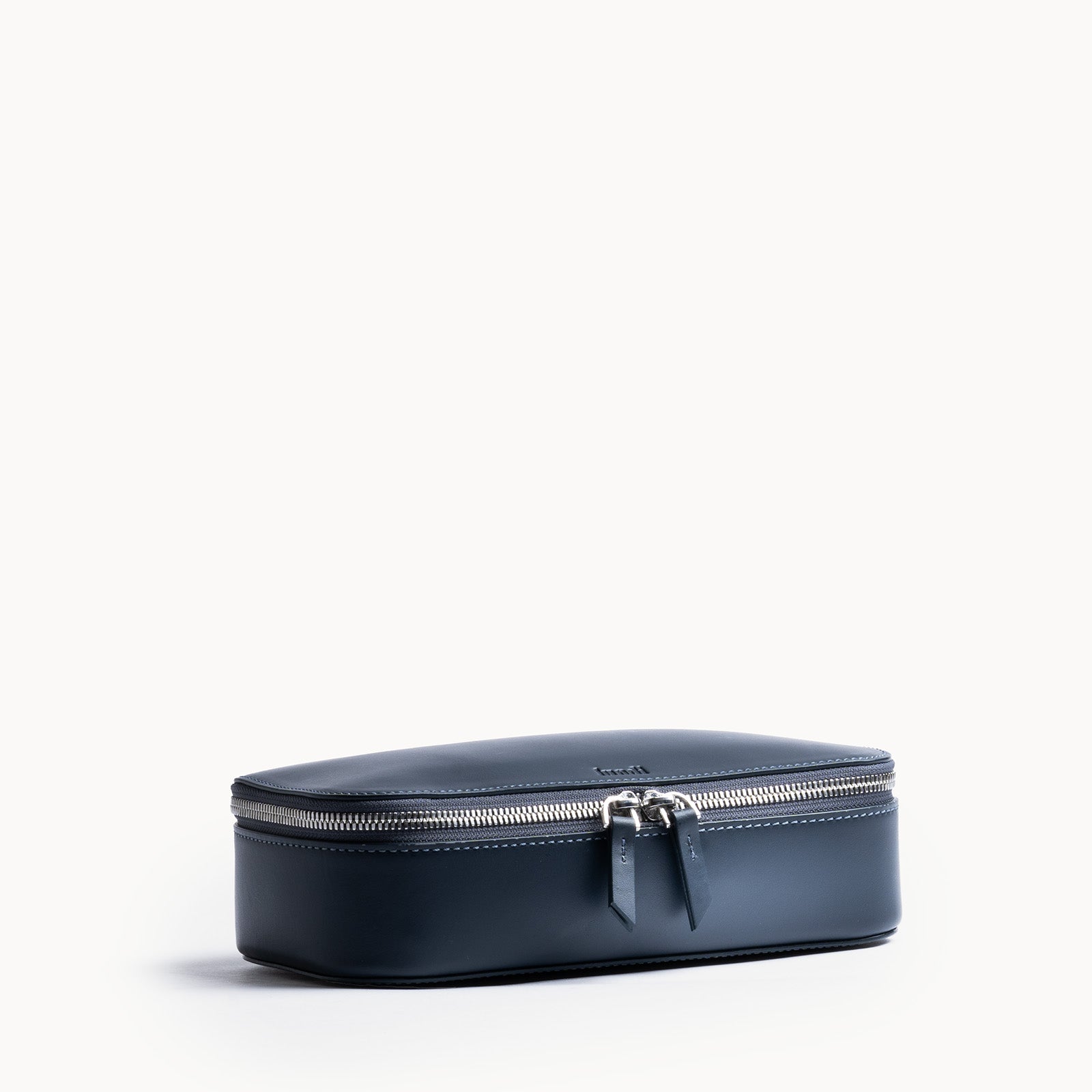 Trousse de toilette homme cuir bleu marine élégante et compacte avec fermeture éclair métallique double.