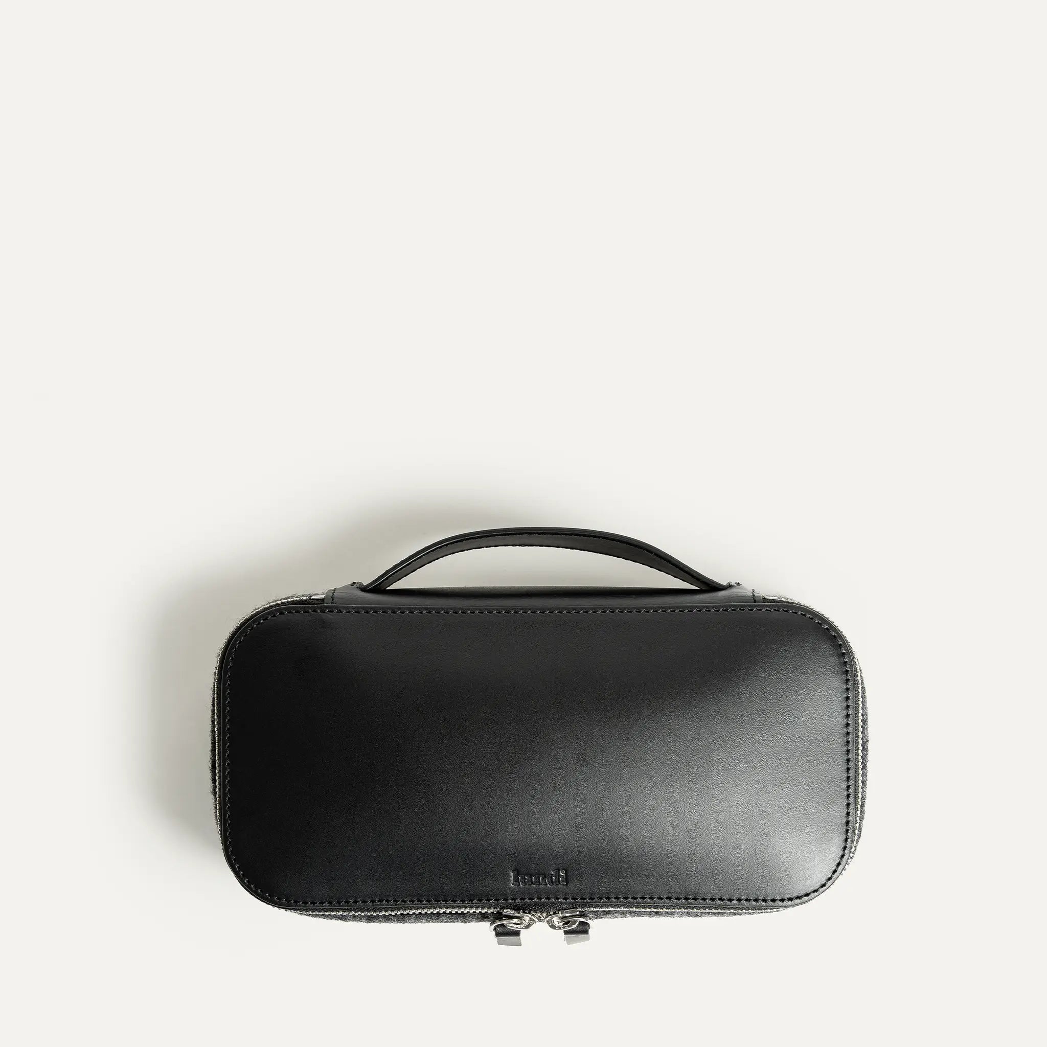 Un cuir au tannage végétal est utilisé pour la construction de cette trousse de toilette. logo lundi embossé